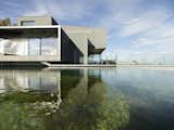 The design of this unique structure was oriented toward the exterior panoramic view. Beyond the western façade is a natural swimming pond.