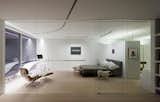 Stark white walls, featuring smooth, curved lines flow throughout the 5,840-square-foot loft. By interchanging luminous and opaque, the ceiling creates a field of ambient and recessed lights, seamlessly delineating the gallery and the living areas.