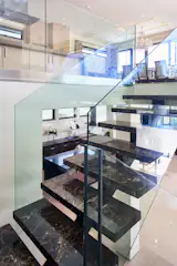 The multi-level house has two kitchens and numerous gathering areas. High ceilings, walls of windows and skylights give the sleek interior a sense of spaciousness.