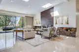 The living room features vaulted ceilings, skylights,  and a wood and marble fireplace.  The fully electric, retracting sliding doors enhance the Santa Monica Bay and mountain view beyond the expansive rear yard.