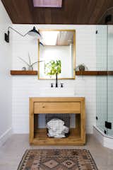 Custom woodwork adds helpful shelving in the bathroom, while a long skylight draws in natural light.