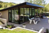 Exterior, Metal Roof Material, Glass Siding Material, Stucco Siding Material, Metal Siding Material, and Shed RoofLine  Photo 15 of 16 in This Can-Do Pool House Cleverly Goes From Private to Party Mode from Modern Mountain Pool House
