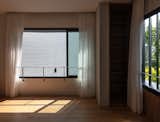 Bedroom, Ceiling Lighting, and Medium Hardwood Floor At one end of the concrete band is a bedroom with a view of a courtyard.  Photo 13 of 22 in Trio Stack (a.k.a Project #10) by Studio Wills + Architects