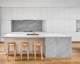 Kitchen, Ceiling, White, Range Hood, Marble, Marble, Recessed, Cooktops, Drop In, and Medium Hardwood Kitchen with Carrara marble island and splash back. Custom cabinetry provides seamless storage options.  Kitchen Cooktops Marble Marble Ceiling White Photos from Cloud House