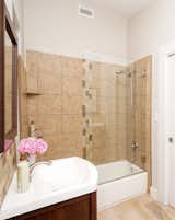 Private bathroom with dual-sinks glass walled shower/tub and featuring Aveda bath products. 