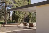 The guest pavilion’s outdoor lounge, shaded by the extended rainwater gutter, seamlessly blends with the natural surroundings. The Nami armchairs, designed by Francesc Rifé for Bivaq, introduce a refined balance of comfort and durability, reinforcing the project’s connection to outdoor living.