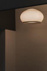 Entrance area of the main house featuring the KNIT pendant lamp by VIBIA, casting a warm and inviting glow. The minimalist design of the lamp complements the serene and understated interior palette, setting the tone for the rest of the home.