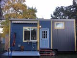 Tiny house entrance with a deck, breakfast nook, and a swing chair