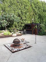 Corten steel retaining wall, rusted steel bird feeder and fire pit