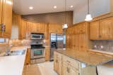 Kitchen, Vinyl Floor, Refrigerator, Wood Cabinet, Range, Ceiling Lighting, Laminate Counter, Granite Counter, Drop In Sink, and Microwave Before Kitchen  Photo 2 of 9 in construction2style Home by construction2style
