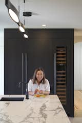 Aya Amornpan, who co-owns and manages three restaurants, in her dream home kitchen. Behind her is the refrigerator and wine fridge.