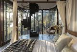 Bedroom, Bed, Chair, Cement Tile Floor, and Floor Lighting Interior view of lower level bedroom looking towards the spiral staircase  Photo 5 of 14 in Tala Treesort by Architecture BRIO