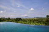 A sinuous infinity pool reflect the curvaceous coastline in the distance