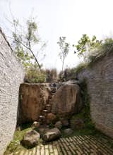 Stone boulders which were discovered during the excavation process and retain the earth.