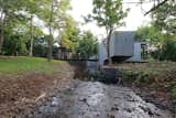 Exterior, Flat RoofLine, House Building Type, Butterfly RoofLine, Concrete Siding Material, and Farmhouse Building Type The seasonal stream changes from a quiet cascading brook to an almost violent monsoon rush.  Photo 1 of 17 in House on a Stream by Architecture BRIO