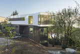Exterior, Concrete, Tile, Prefab, House, Wood, Metal, and Flat From the edge of the property the graceful entry and landscape gently slope around to a lower yard.  Exterior Tile Metal Concrete Wood Photos from Farwell