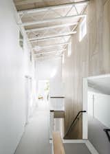 The birch plywood of the back stairs and loft ceiling is laid in a large tile pattern and stained with a varying amount of white sheen. Each line of tiling connects the spacing of the trusses to each stair tread to create a unified frame that one moves through. 
