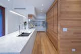 Kitchen, Marble Counter, White Cabinet, Wall Oven, Wood Cabinet, Range Hood, Cooktops, Medium Hardwood Floor, Refrigerator, Undermount Sink, Ceiling Lighting, and Dishwasher  Photo 8 of 10 in New Farm House by Vibe Design Group