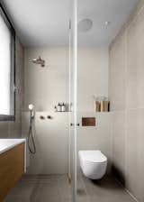 The bathrooms and bedrooms are designed in soft hues inspired by the sunrise and sunset, featuring large, sandy tiles and textured shower walls.