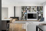  A custom-built bookshelf became the focal point of the living room, incorporating books, décor, a TV, sound system, gas fireplace, and ample storage.