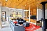 Living Room, Hanging Fireplace, Sofa, Ceiling Lighting, Concrete Floor, and Wood Burning Fireplace  Photo 8 of 13 in GRAND LAKE COTTAGE by RHAD Architects