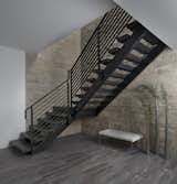 The stairs in this 2017 Franklin home seemingly float on a frame tubular steel, painted black, in front of the 20’ floor to ceiling limestone wall.  The only supports on the staircase other than the top and bottom are where the landing attaches to the front wall.  Treads and landing are rift cut white oak stained to match the entry door.  The simple linear rail was crafted from rectangular bar stock and tube stock.  The open design allows light from the main floor to flood the opening.  The lower level features a stone-like luxury vinyl flooring that was selected for it’s warm look and feel and because it is easier under foot than concrete or ceramic tile.  