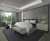 The contemporary master suite features a standout custom upholstered headboard with wood headboard frame and upholstered bed frame.  The owners of this Franklin home, completed in 2017, also installed blind pockets, to allow them to darken the room with blackout shades when needed, that also conceal sheer custom drapery that showcases the lake views from full floor to ceiling windows while also softening the look and feel of the room.  The cove ceiling includes hidden LED lighting which adds architectural detail and function.  The intimate sitting area in front of the floor to ceiling windows gives an added warmth to the room while the wide plank French oak floors in a neutral palate allow the elements of this room to really shine. 