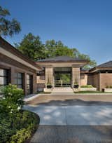 Completed in 2017, this home in Franklin, inspired by the Frank Lloyd Wright Robie House in Chicago features large overhangs and a shallow sloped hip roof.  The exterior features long pieces of Indiana split-faced limestone in varying heights and elongated norman brick with horizontal raked joints and vertical flush joints to further emphasize the linear theme.  The courtyard features a combination of exposed aggregate and saw-cut concrete while the entry steps are porcelain tile.   The siding and fascia are wire-brushed African mahogany with a smooth mahogany reveal between boards.  
