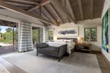 The master bedroom suite at this Montecito hacienda is quite roomy and does have a cozy fireplace, in addition to an open-beam cathedral ceiling. It also hosts dual walk-in closets and two sets of French doors opening to a pergola.