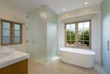 This magnificent home's chic master bathroom features a freestanding soaking tub overlooking the orchard. 