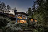 Beautifully sited on .27 old growth cedar forested acres and surrounded by native plantings and zen-like grounds, the home is a peaceful escape from the busy world yet is only moments away. Integrated into its quiet natural setting, the original design has many NWRS signature design features connecting the in to the outdoors. The interior living spaces blend seamlessly with the exterior via extended covered patios and porches, and walls of floor-to-ceiling glass; which also provide a rich natural light and private wooded views from every room. Vaulted clear cedar ceilings run seamlessly out to the exterior eaves and large overhangs providing cover to the generous deck, patios and walkways. Built-in soffit lighting adds a cozy warmth and accents the architecture and vaults.