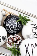 If you're looking to DIY your modern Christmas decor this year, look no further than these simple black and white orbs inscribed with holiday-inspired messages. All you need to create this look is the ornaments, a white paint pen, and a black Sharpie. These modern Christmas ornaments are a great way to stay on budget and on trend.
