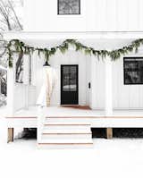 Modern outdoor Christmas decorations add a hint of the holidays without being boastful and overdone. Here, just a touch of greenery is all that's needed to create this understated yet unforgettable scene. 