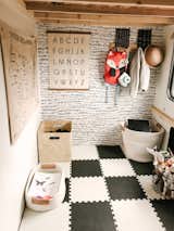 Brayden's playroom, located under his lofted bed, is clad in black-and-white foam tiles and a coordinating accent wall.