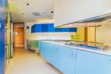 The kitchen feels playful with ranging hues of blue and continued triangular shapes.