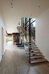 In the home’s generous entryway, glass and steel support the floating french oak stairway.