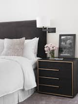 A Cashmere headboard cradles the bed. The brass finished dark wood bedside table further highlights the sultry Master Bedroom.