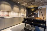 In the piano room, backlit niches showcase the client’s Japanese sword collection, while the discreet surrounding cabinetry holds music. 