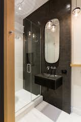 Bath Room, Porcelain Tile Wall, Wall Mount Sink, Pendant Lighting, Recessed Lighting, Porcelain Tile Floor, Enclosed Shower, and Stone Counter The second bathroom references Japanese design through the designer's choice of greys, charcoals, and whites as accent colours for tiling.   Photo 10 of 11 in Cooper Street Residence by Sarah Brown