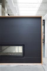 The simple two-sided fireplace warms up the industrial space. 