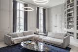 Living Room, Sofa, Pendant Lighting, Sectional, Storage, Bookcase, Coffee Tables, Lamps, Rug Floor, Light Hardwood Floor, Ceiling Lighting, Table Lighting, Shelves, and Accent Lighting  Photo 4 of 11 in Modern Meets Traditional in This Paris Home