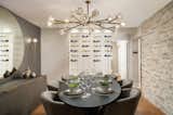 Dining Room, Table, Chair, Medium Hardwood Floor, Storage, Accent Lighting, Pendant Lighting, and Ceiling Lighting  Photo 5 of 15 in Inside a Moody Transitional Contemporary Tampa Residence Designed for Optimal Flow by UpSpring PR