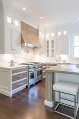 Kitchen, Wood Counter, Recessed Lighting, Dark Hardwood Floor, Range Hood, Marble Counter, Ceiling Lighting, Wood Cabinet, Marble Backsplashe, Range, and White Cabinet  Photo 4 of 14 in Harmonious Luxury Kitchen in Southampton by UpSpring PR