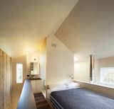 The bedroom with open bathroom behind. The volume of the bathroom shears the open geometry of the gabled roof form.