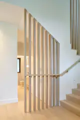 West Side Clerestory - Entry stair guardrail and handrail detail continue at base of stair with peek-a-boo view through to powder room.