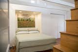 The light-filled master bedroom includes a cedar-lined closet, half bath on the same level, and bathing functions at the top of the steps.