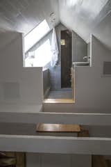 In the reclaimed attic space above the master bedroom are the shower and bathtub, with skylight looking up into  maple tree branches, evoking a feeling of bathing in a tree house.