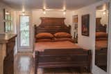 The guest bedroom is an intimate space that was originally a porch on the southeast side of the home. The room features windows on three sides–including one looking up the lane that runs farther into the property.