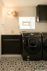 Previously housing a toilet, shower and laundry area, Waldron Designs removed the shower and opened up the dark laundry room, raising the ceiling and painting existing wood cabinetry for a modernized touch on a budget.