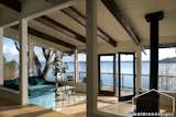 Beams guide the eye to the wall of windows with a magnificent view of the water. The wood-paneled ceiling and walls were painted to give emphasis to the beams and enhance the directional view.